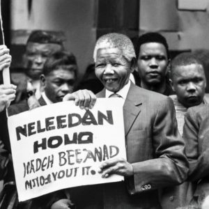 Nelson Mandela holding a sign